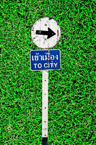 The Sign of to city on green grass background — Stock Photo, Image