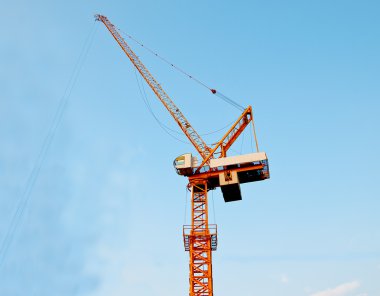 The Crane working on construction site on blue sky background