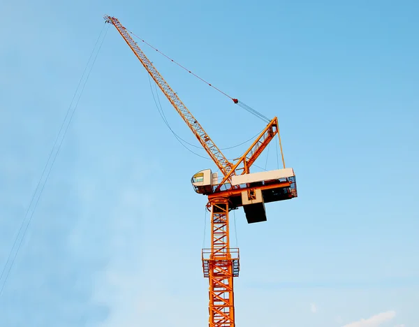 Кран, працює на будівельному майданчику на фоні синього неба — стокове фото