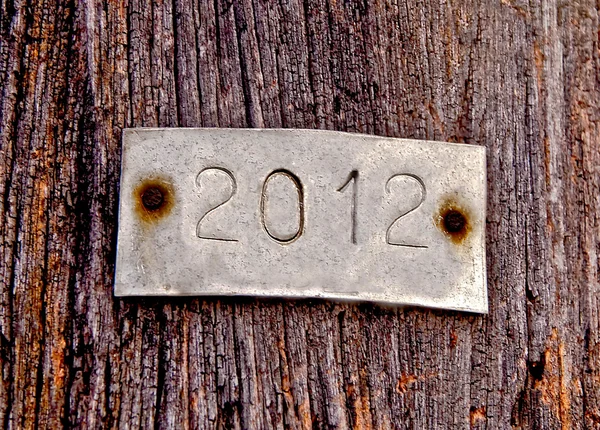 La placa de aluminio de 2012 sobre fondo de madera vieja —  Fotos de Stock
