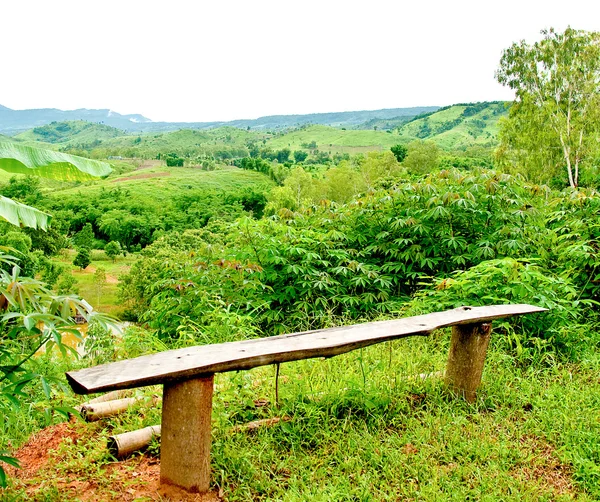 O banco de madeira longo na montanha — Fotografia de Stock