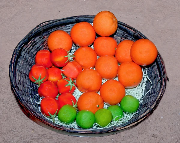 Rzeźba pomarańczowy pomidor i cytryny na kosz bambusowy — Zdjęcie stockowe