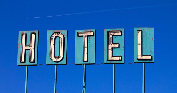 Grunge Covered Hotel Sign And Airplane Isolated On Blue