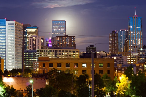 Volle maan stijgt achter denver colorado skyline in de schemering — Stockfoto