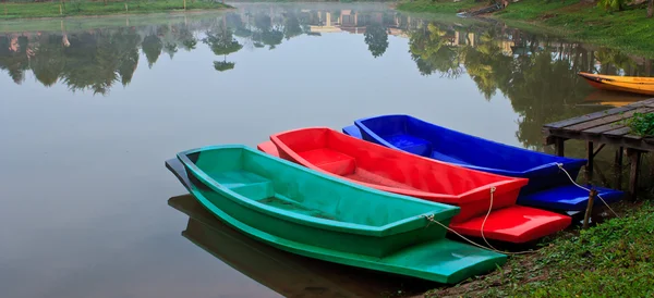 Riflessione variopinta di barca e albero nel lago — Foto Stock