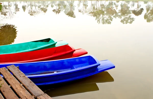 Bateau coloré et reflet d'arbre dans le lac — Photo