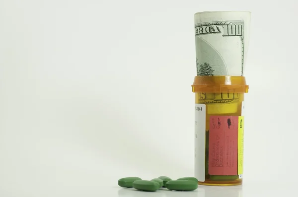 Prescription bottle with money in it — Stock Photo, Image
