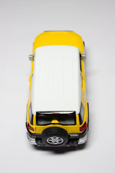 O jipe amarelo em um fundo branco — Fotografia de Stock