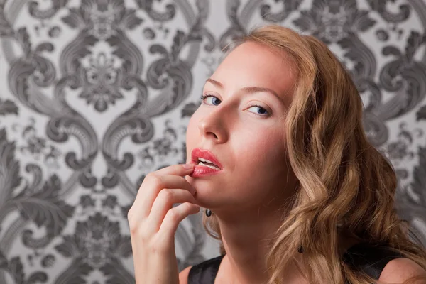 Vacker blond kvinna med fingret på hennes läppar — Stockfoto