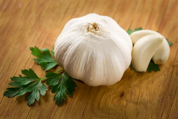 Fresh garlic head and cloves on wood — Stock Photo, Image