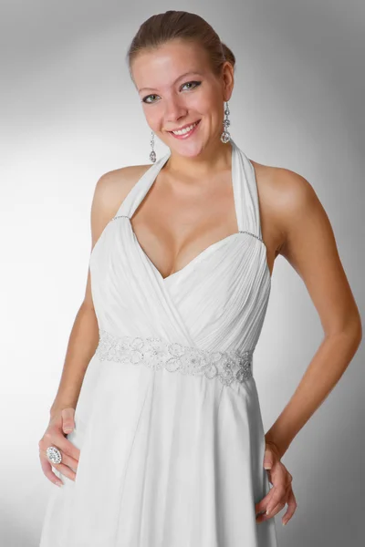Vacker kvinna bär lyxiga bröllopsklänning över grå studio bakgrund — Stockfoto