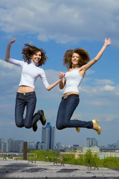 Twee leuke meisjes springen en plezier — Stockfoto