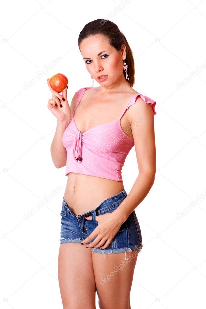 Cute young girl in blue shorts holding an apple isolated