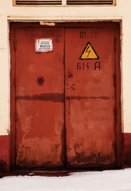 Grunge rusty orange door, danger high voltage keep out in russia clipart