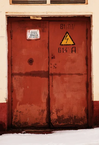 Grunge rostig orange dörr, fara högspänning hålla i Ryssland Stockbild
