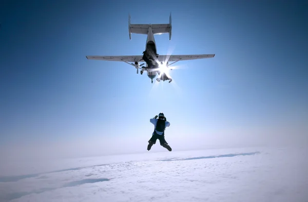 Група гірськолижників, що виходять з літака над хмарами — стокове фото