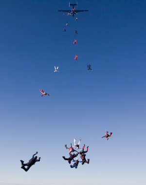 Group of skydivers exit plane clipart