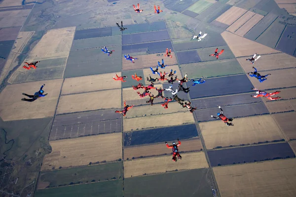 Grupo de pára-quedistas voando em formação — Fotografia de Stock