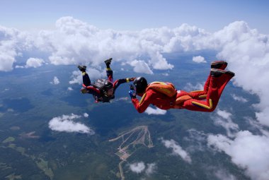 iki skydivers bulutların üzerinde uçuyor