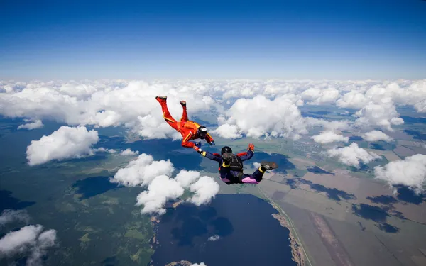 Two skydivers flying over the clouds — Stock Photo, Image
