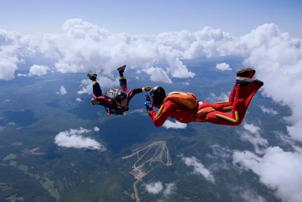 Two skydivers flying over the clouds — Stock Photo, Image