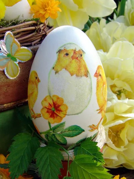 Пасхальное яйцо ручной работы с салфеткой и желтыми тюльпанами — стоковое фото