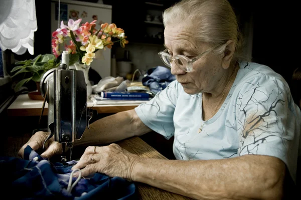 바느질 하는 동안 고위 여자 — 스톡 사진
