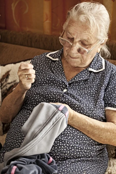 Vanhempi nainen ompelun aikana — kuvapankkivalokuva