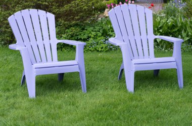 Two purple chairs on a green lawn clipart