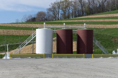 Storage tanks on a gas well site clipart