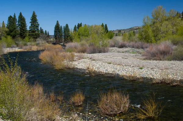 stock image River flowing under iron bridge