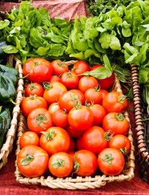 Tomatoes and basil on display in baskets clipart