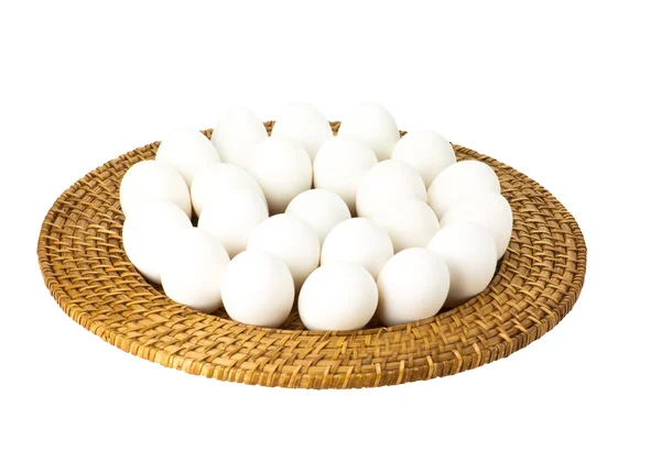 Білі яйця на плетеному лотку — стокове фото