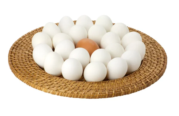 Huevos en una bandeja de mimbre con un huevo marrón — Foto de Stock