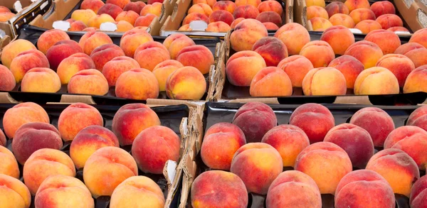 Perziken tentoongesteld in de boerenmarkt — Stockfoto