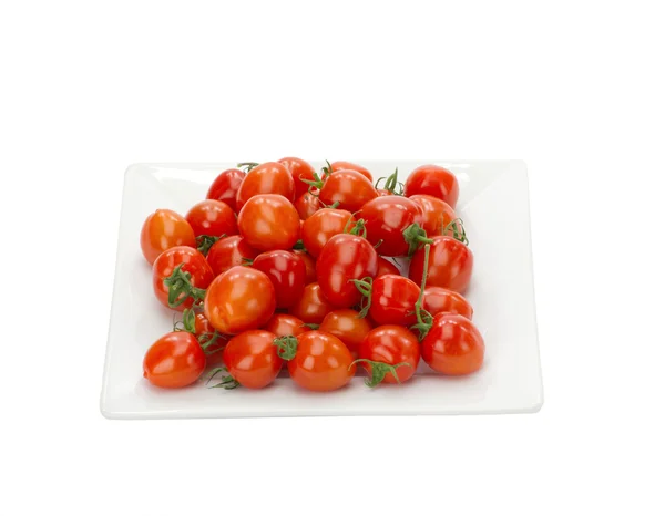 Pomodori rossi ciliegia su piatto bianco isolato — Foto Stock