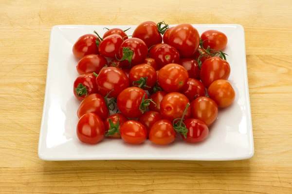 Red cherry tomatoes on white plate — Stock Photo, Image