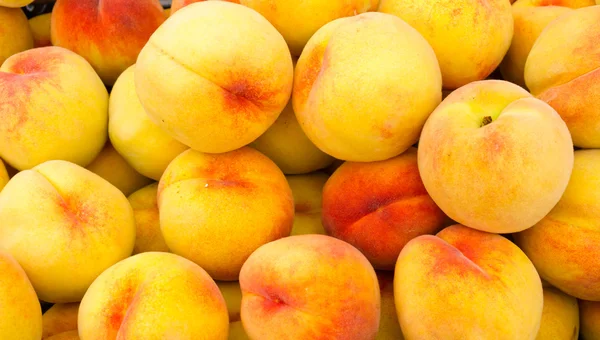 Gele perziken op display — Stockfoto