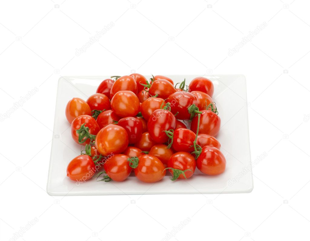 Red cherry tomatoes on white plate isolated