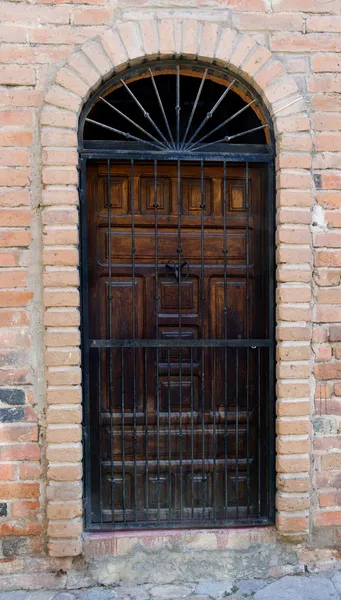 Old wooden door surronded by brick — Stock Photo, Image
