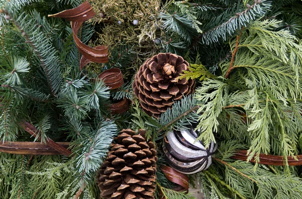 Christmas arrangement with greens ornament and pinecones — Stock Photo, Image