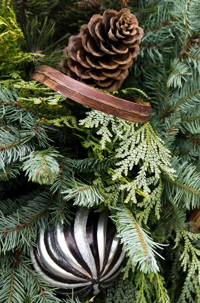 Christmas arrangement with greens ribbon ornament and pinecones — Stock Photo, Image