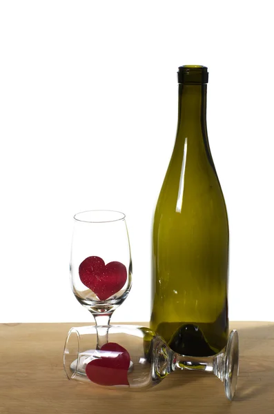 Garrafa WIne em uma mesa com óculos e corações — Fotografia de Stock