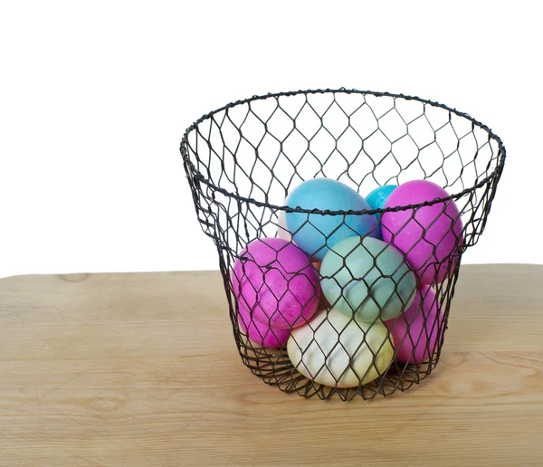 Wire basket of colored eggs — Stock Photo, Image