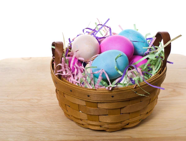 Wiklinowy kosz z kolorowymi jajkami — Zdjęcie stockowe