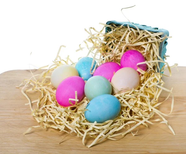 Small basket with colorful eggs spilling out — Stock Photo, Image
