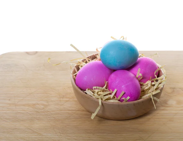Small wooden bowl with colorful eggs — Stock Photo, Image