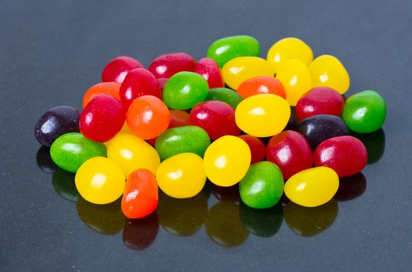 Jelly beans on glossy black — Stock Photo, Image