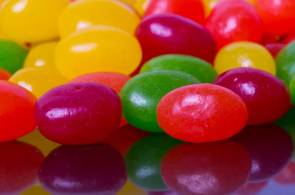 Closeup of jelly beans reflected in glossy black — Stock Photo, Image