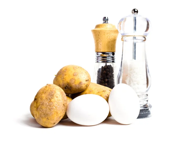 Nieuwe aardappelen, eieren en zout en peper shakers — Stockfoto